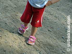 Sandaalit jalassa hiekalla