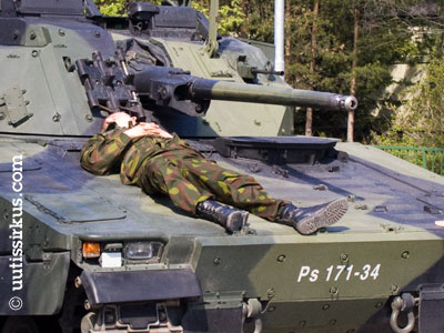 Varusmies nukkuu panssariajoneuvon konepellillä