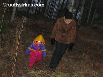 äiti kulkee lapsen kanssa synkeässä metsässä
