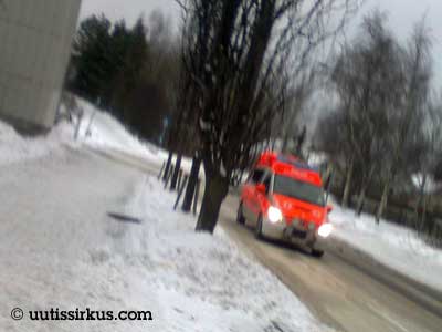 ambulanssi ajaa sohjoisella väylällä aavistuksenomaisesti tärähtäneessä valokuvassa