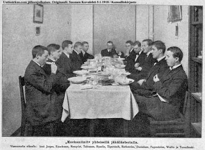 11 miestä lounaspöydän ääressä