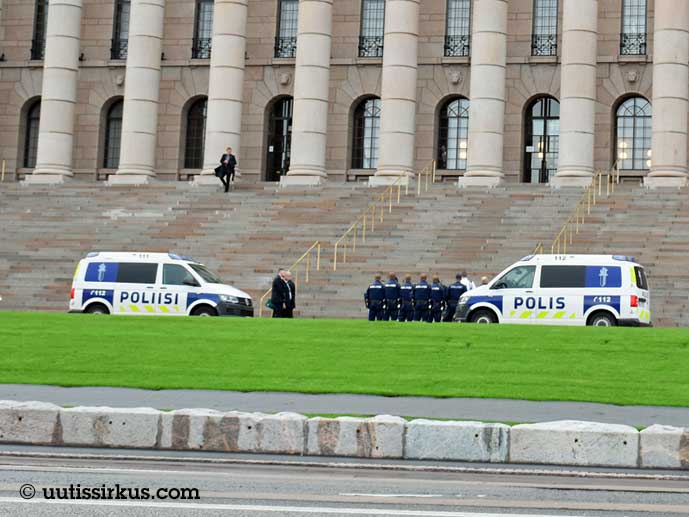 kaksi poliisiautoa ja poliiseja eduskuntatalon portaiden edustalla