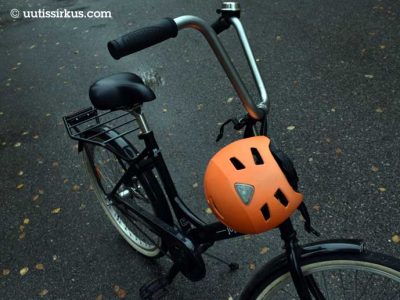 oranssi pyöräilykypärä pysäköidyn Jopon ohjaustangossa