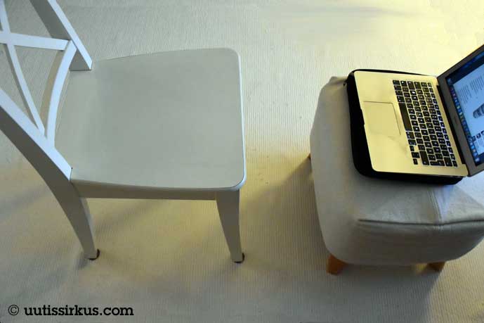 Valkea ruokapöydän tuoli ja rahi, jolla läppäri, kaiken alla valkoinen matto