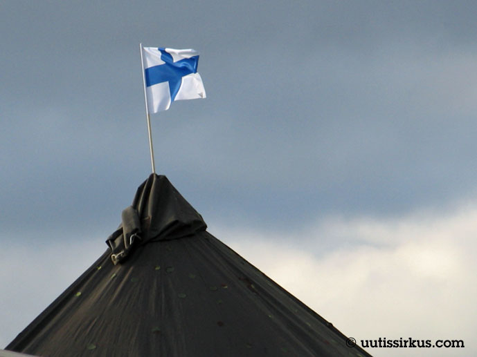 Suomen lippu liehuu puolijoukkueteltan katolla