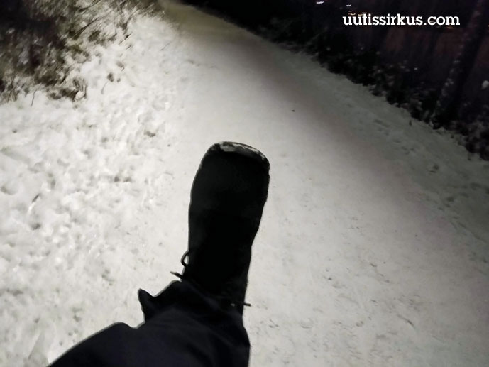 musta kenkä osumassa lumisen liikuntareitin pintaan