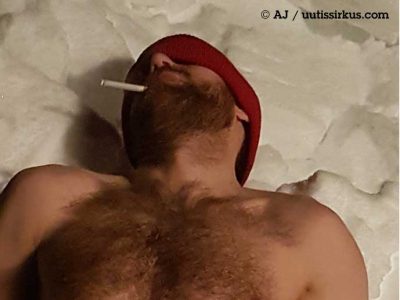 mies makaa lumihangessa pipo päässä ilman paitaa, tupakki suussa