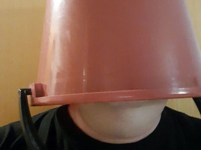 Mies punainen ämpäri päässään