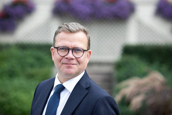 Pääministeri Petteri Orpo, rintakuva kesäisen vihreässä maisemassa vuonna 2023